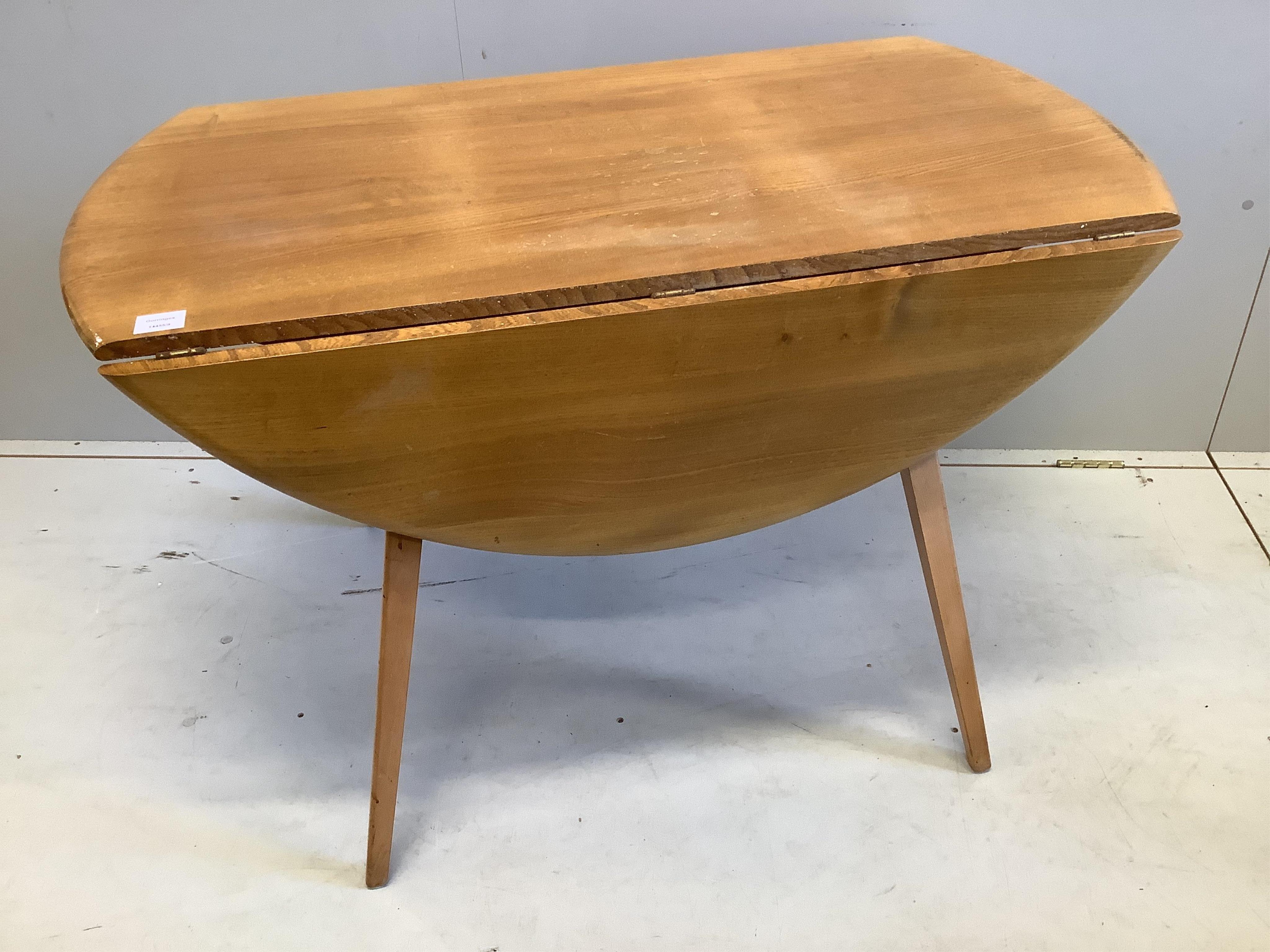 An Ercol circular elm and beech drop flap dining table, diameter 112cm, height 71cm, and four Ercol chairs. Condition - fair